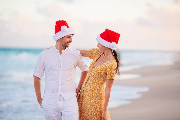 Bożenarodzeniowa Szczęśliwa Para W Santa Kapeluszach Na Wakacje Na Plaży