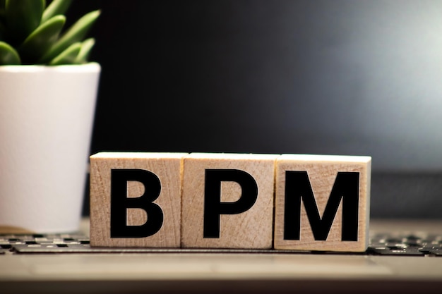 Zdjęcie bpm business process management written on a wooden cube in a office desk