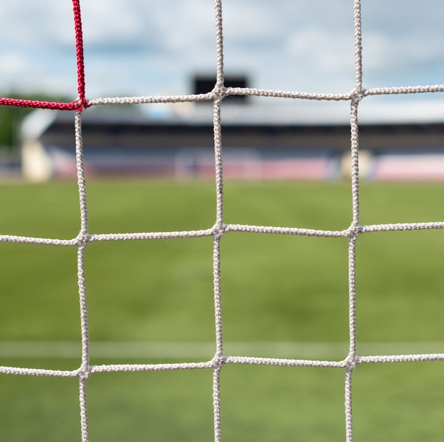 Bramki do piłki nożnej na stadionie. Tło boisko do piłki nożnej. Kolor białych i czerwonych siatek.