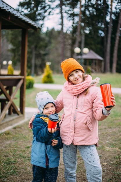 Brat i siostra bawią się i śmieją na zewnątrz jesienią w parku