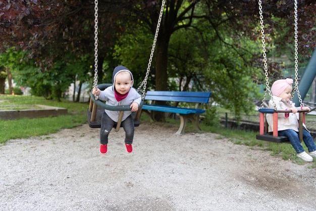 Brat i siostra bawią się na huśtawce