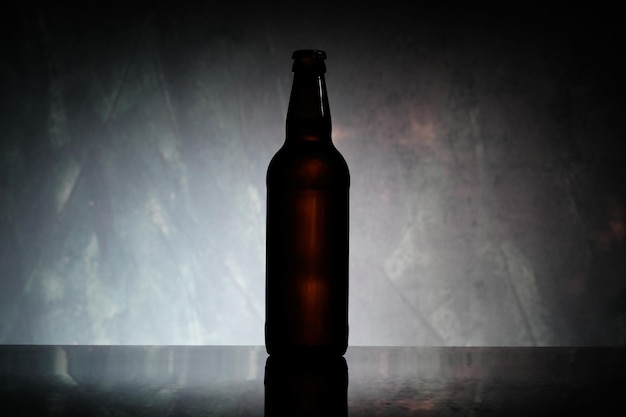 Brązowa butelka piwa lub cydr na jasnoniebieskim tle Brązowa butelka piwa na szarym tle