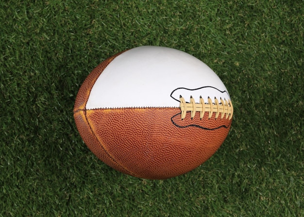 Zdjęcie brązowa skórzana piłka do futbolu amerykańskiego na trawniku
