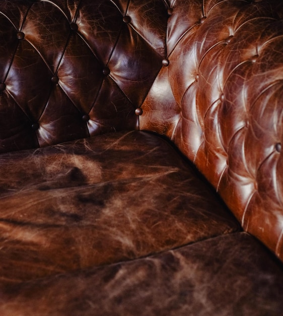 Zdjęcie brązowa skórzana tapicerka typowej kanapy chesterskiej
