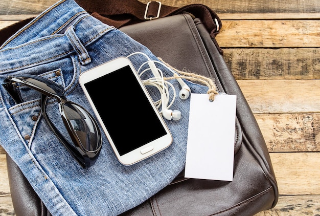 Brązowa skórzana torbablue jeansmart telefon i słuchawka na drewnianym stole