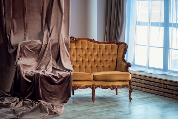 Brązowa Sofa W Stylu Vintage Z Aksamitną Zasłoną We Wnętrzu Pokoju W Stylu Minimalistycznym. Panoramiczne Okna