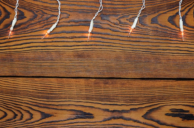 Brązowe drewniane tło z białą świecącą girlandą