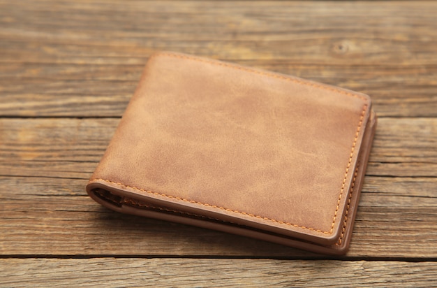Brązowy błyszczący portfel na drewnianej powierzchni