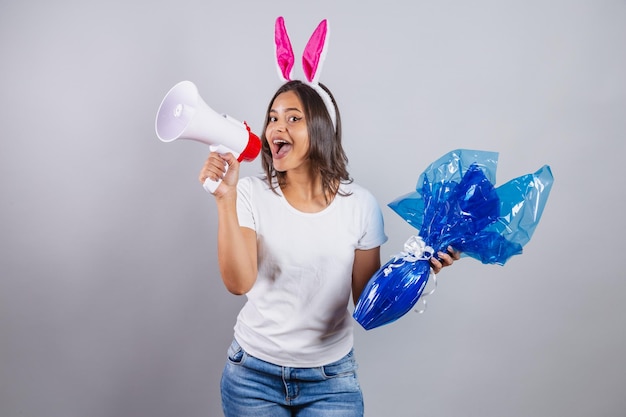Brazylijka z uszami królika wielkanocnego trzymająca megafon i jajko wielkanocne