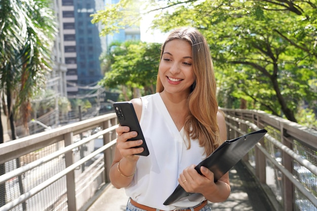 Brazylijska Kobieta Biznesu Wykonawczego Spacerująca Po Zrównoważonej Zielonej Metropolii Sprawdzająca Telefon Komórkowy Na Zewnątrz