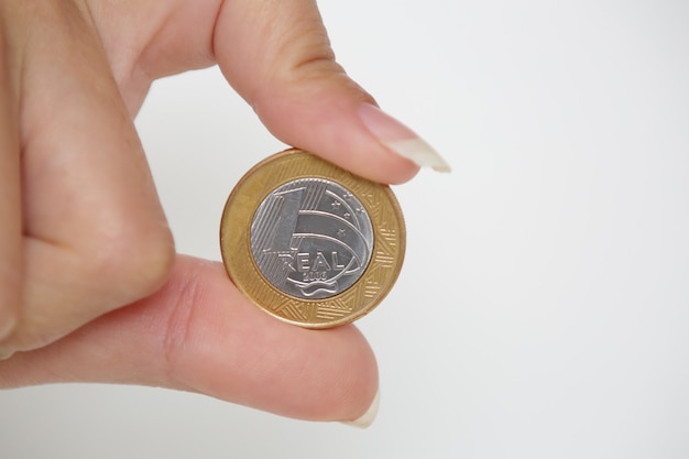 Brazylijska moneta 1 Real w kobiecej dłoni