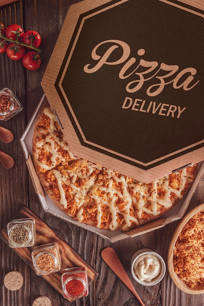 Brazylijska pizza z mozzarellą, kurczakiem, catupiry i oregano w pudełku dostawczym (Pizza de frango com catupiry) - widok z góry.