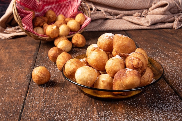 Brazylijski cukierek bolinho de Chuva, pokryty cukrem, na rustykalnym drewnie, selektywne skupienie