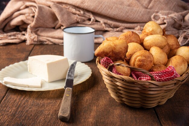 Brazylijski cukierek bolinho de Chuva, umieszczony w koszu, ser, rustykalne drewno, selektywne skupienie.