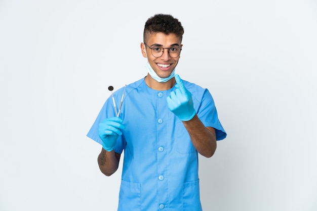 Brazylijski dentysta trzymając narzędzie na białym tle robi nadchodzący gest