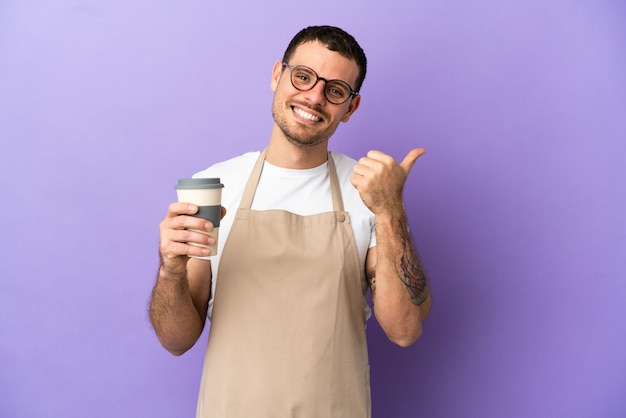 Brazylijski kelner restauracji na odosobnionym fioletowym tle z kciukiem w górę gestem i uśmiechem