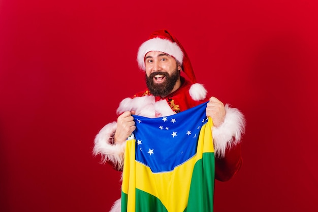 Brazylijski święty mikołaj młody kaukaski mężczyzna z brazylijską flagą
