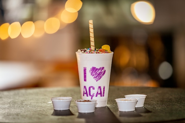 Brazylijskie acai mrożone w styropianowym kubku ze skondensowanym mlekiem i cukierkami Dla Miłośników acai