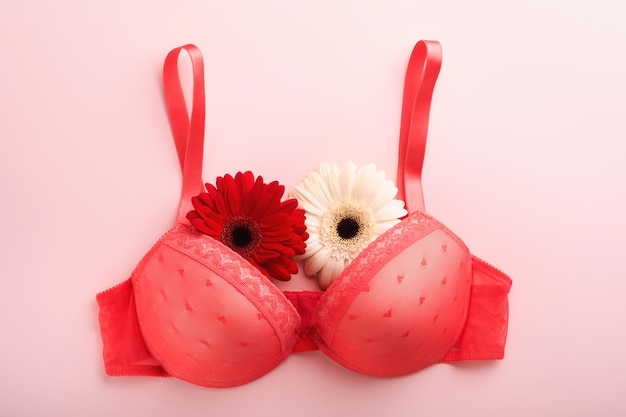 Breast Cancer Awareness Ribbon Biało-czerwone gerbery z różową wstążką leżącego na kobiecym biustonoszu na tle Świadomość raka piersi i październik Różowy dzień Światowy dzień raka Widok z góry Makieta