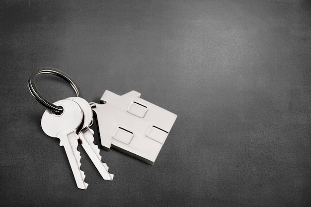 Zdjęcie brelok w kształcie domu i klucze na biurku