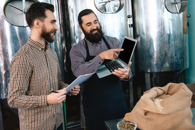 Brewer Man wskazuje na mikrobrowar na ekranie laptopa