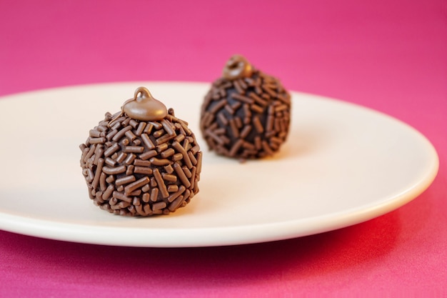 Brigadeiro tradycyjny brazylijski słodki na różowej powierzchni Selektywne skupienie