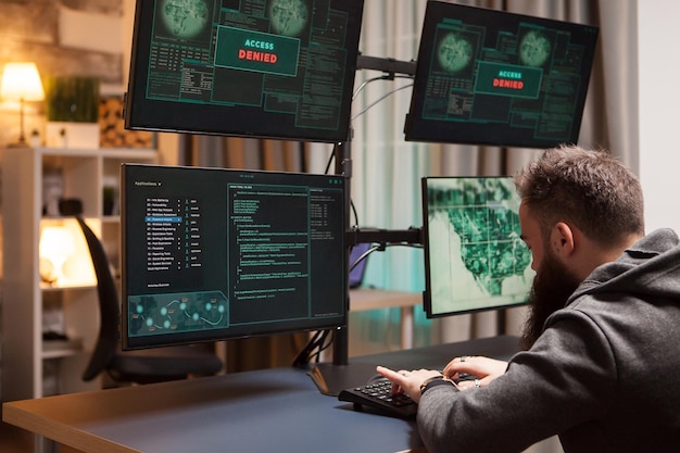 Brodaty cyberterrorysta uzyskuje dostęp podczas pisania wirusa. Przestępca internetowy.