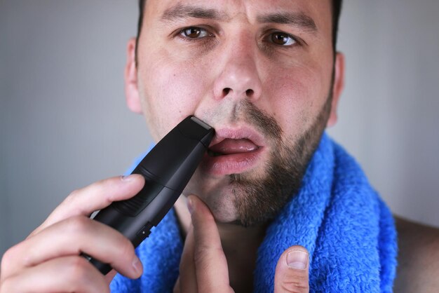 Zdjęcie brodaty mężczyzna golący się elektrycznie