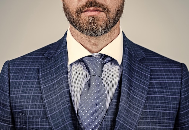 Brodaty mężczyzna twarz z nieogolonym zarostem przycięty widok w modzie formalnym szarym tle broda