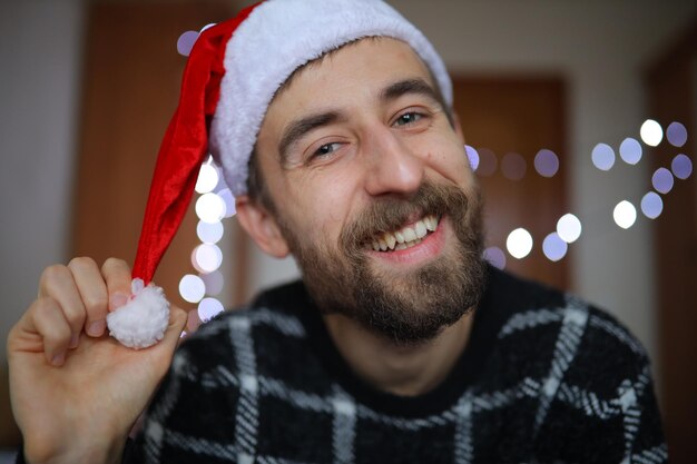 Brodaty mężczyzna w czapce Świętego Mikołaja Mężczyzna uśmiecha się i cieszy noworoczny portret zbliżenia