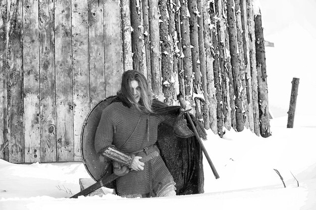 Zdjęcie broń młodego wojownika w kolczudze uzbrojonego w miecz i topór