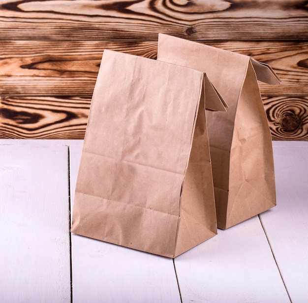 Zdjęcie brown lunch bag na białym drewnianym stole