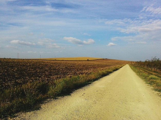 Brudna droga pośrodku pola na tle nieba