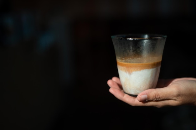Brudna kawa - szklanka espresso zmieszana z zimnym świeżym mlekiem w kawiarni kawiarni i restauracji