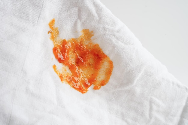 Brudna plama pikantnego sosu na tkaninie do mycia proszkiem do prania koncepcja czyszczenia pracy domowej