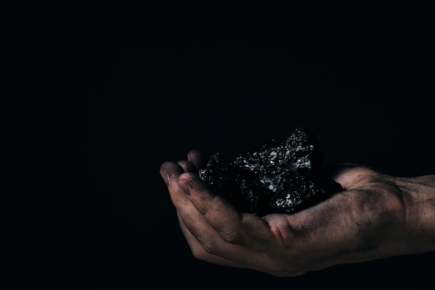 Brudne ręce górnik trzymający węgielWydobycie węgla ciężkiego