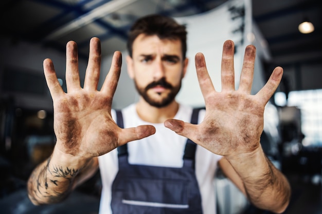 Zdjęcie brudne ręce pracowitego pracownika w kombinezonie. koncepcja pracy ręcznej.