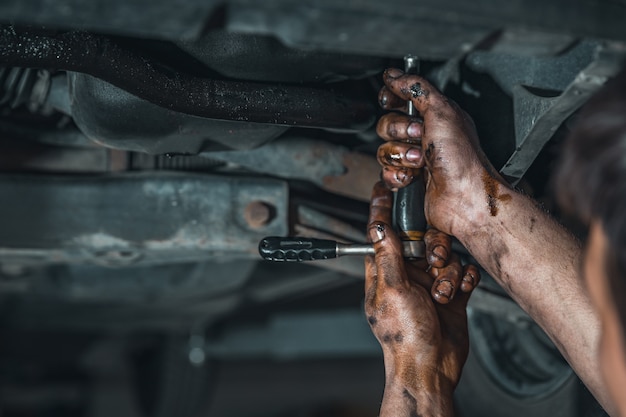 Brudne ręce technika podczas naprawy samochodu