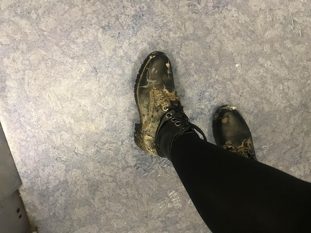 Brudne, zabrudzone, zniszczone damskie buty na stopach
