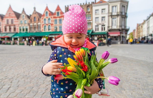 Zdjęcie brugia belgia 23 kwietnia 2022 dziecko z bukietem tulipanów selektywne skupienie