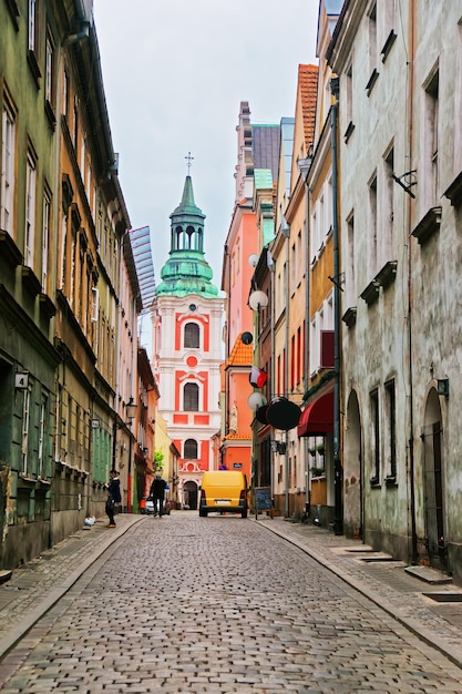 Brukowana ulica prowadząca do kościoła św Stanisława na Starym Mieście w Poznaniu, Polska. Ludzie w tle