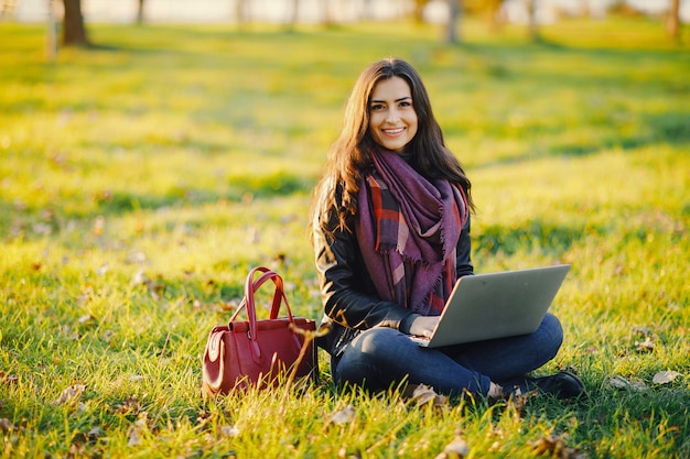 Brunetka Dziewczyna Pracuje Na Jej Laptopie W Parku Podczas Jesieni