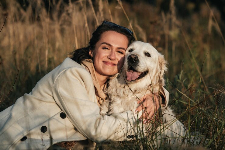 brunetka dziewczyna przytulanie biały golden retriever w polu