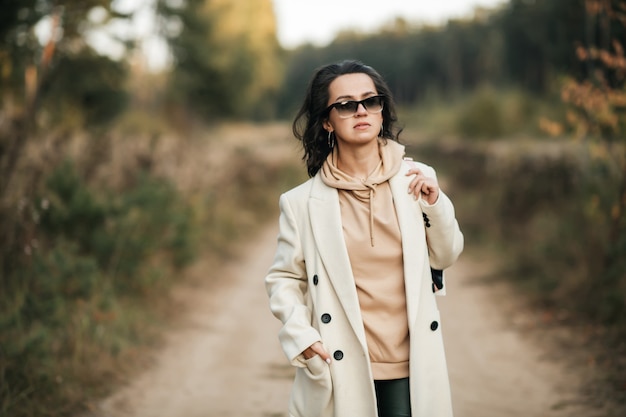 brunetka dziewczyna z plecakiem na leśnej ścieżce