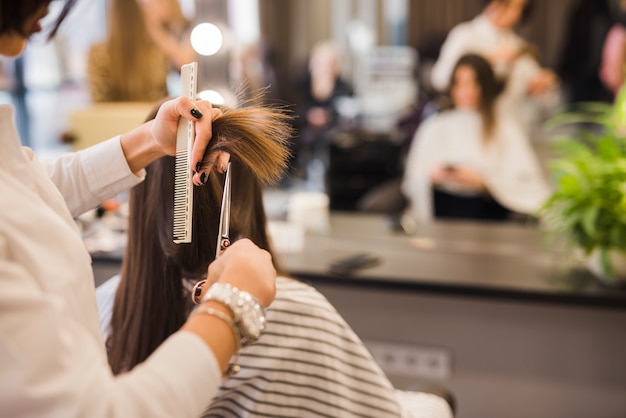 Brunetka kobieta coraz jej włosy cięte