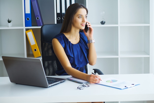 Brunetka Kobieta Patrząc Na Telefon Podczas Pracy