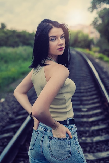 Brunetka młoda kobieta stojąca na torach kolejowych