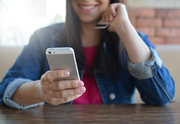 Brunetka W Dżinsowej Kurtce Je Obiad W Kawiarni I Używa Telefonu