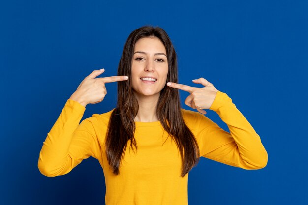 Brunetki młoda kobieta gestykuluje nad błękit ścianą