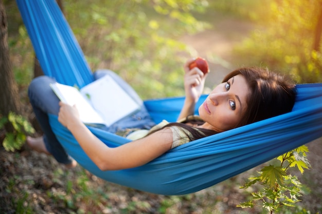 Brunetki piękna kobieta relaksuje w hamaku